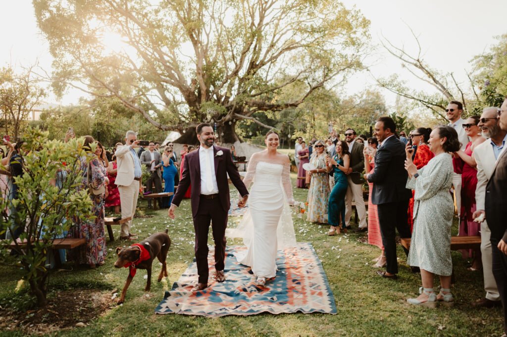 Los novios caminan entre sus invitados en una ceremonia al aire libre